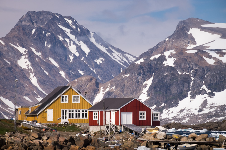 Two brightly painted houses in front of distant mountain