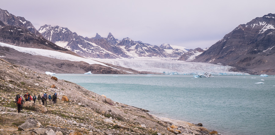 Group hiking along the fjord with the Karale glacier prominent in the background