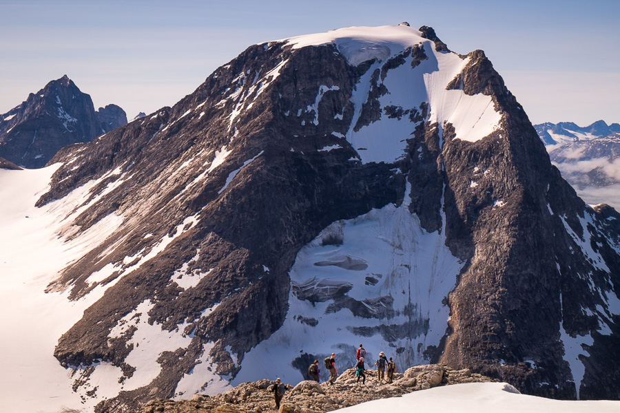 8 of my trekking companions at the edge of a ridge, dwarfed by the mountain that lies across the valley