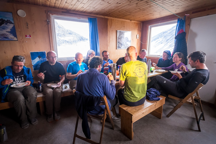 The group sitting around the dining table at Tasiilaq Mountain Hut eating lunch