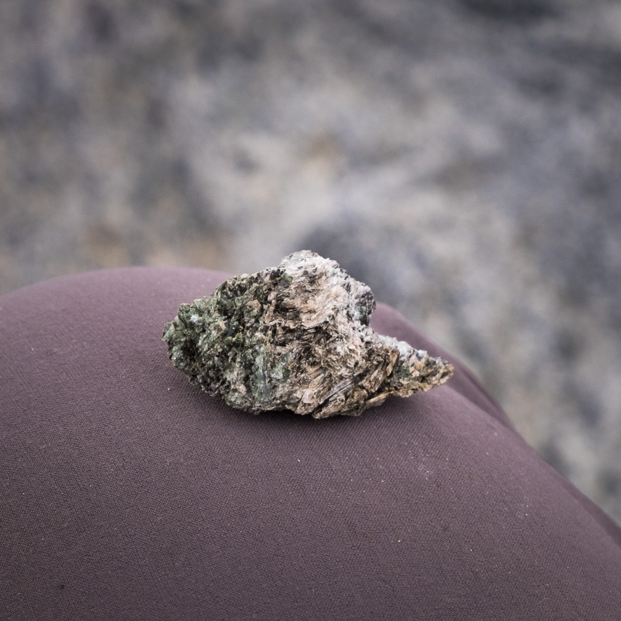 Close-up of a rock formed completely of long green and white mineral crystals