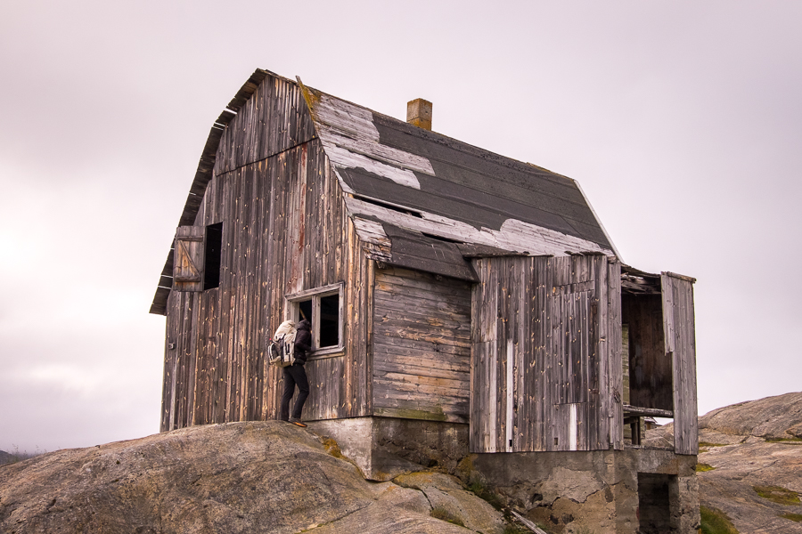 My friend looking in the window of one of the derelict buildings at Assaqutaq near Sisimiut, West Greenland