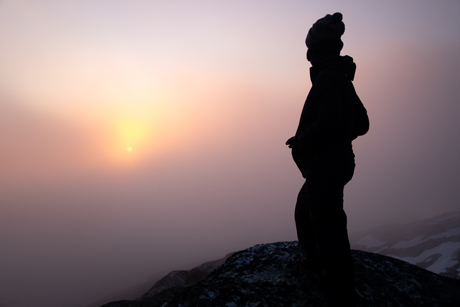 silhouette with the sunset obscured by fog in the Sermilik Fjord - East Greenland