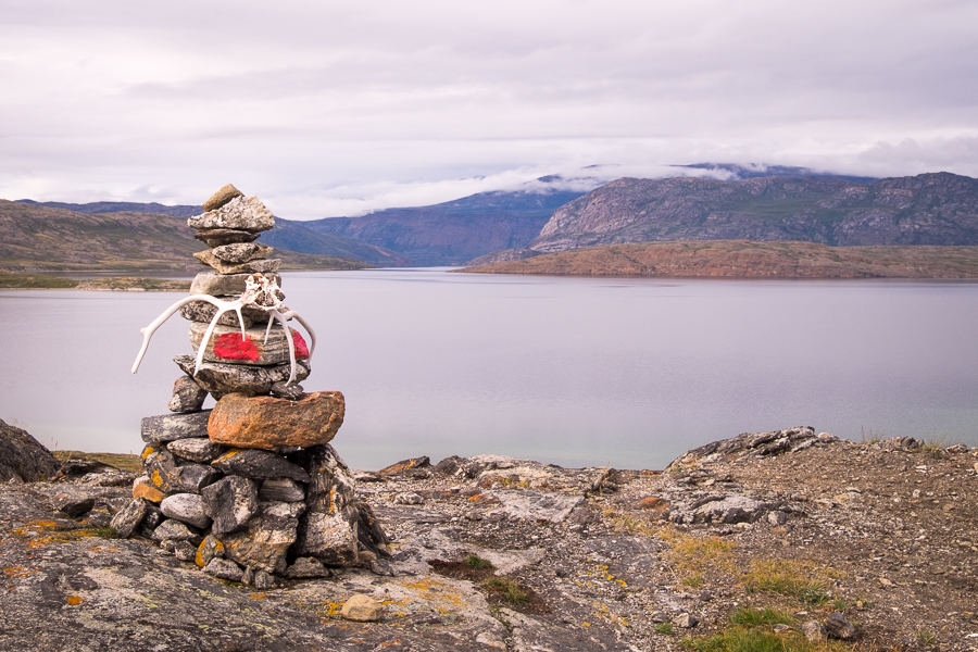 Stone cairn with reindeer antlers in front of a lake - Arctic Circle Trail - West Greenland