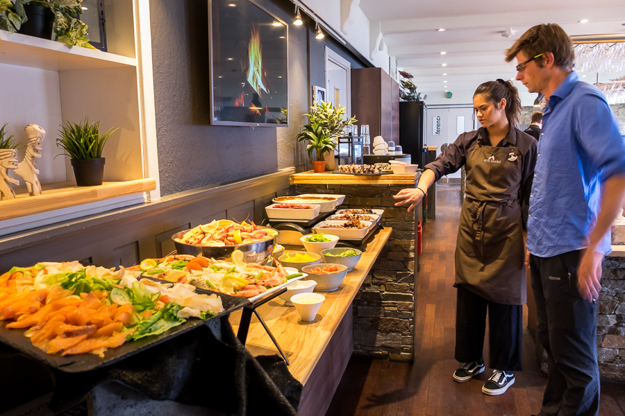 Wait staff at the Nasaasaaq Restaurant and Brasserie explaining to Tyson all the different elements of the Typical Greelandic Buffet - Sisimiut, West Greenland