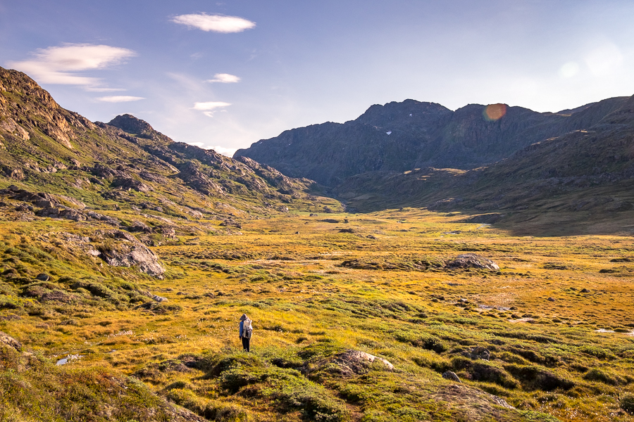 Hiker approaching the boggy ground at the bottom of the valley -  Sisimiut UFO hike - West Greenland