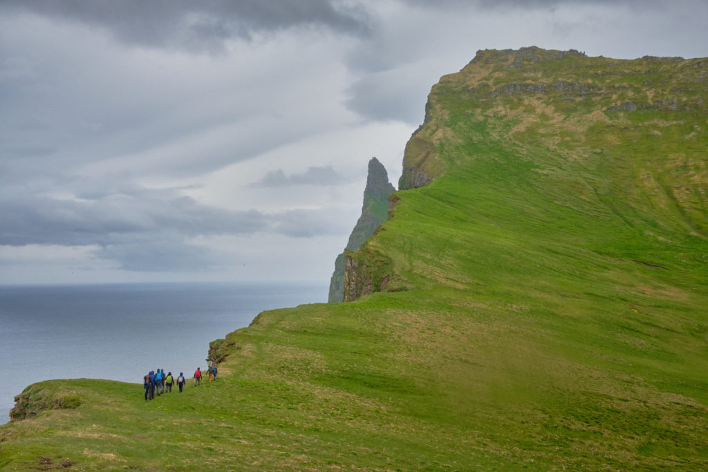 Group of hikers making their way towards the higher portion of Hornbjarg - Hornstrandir - Iceland