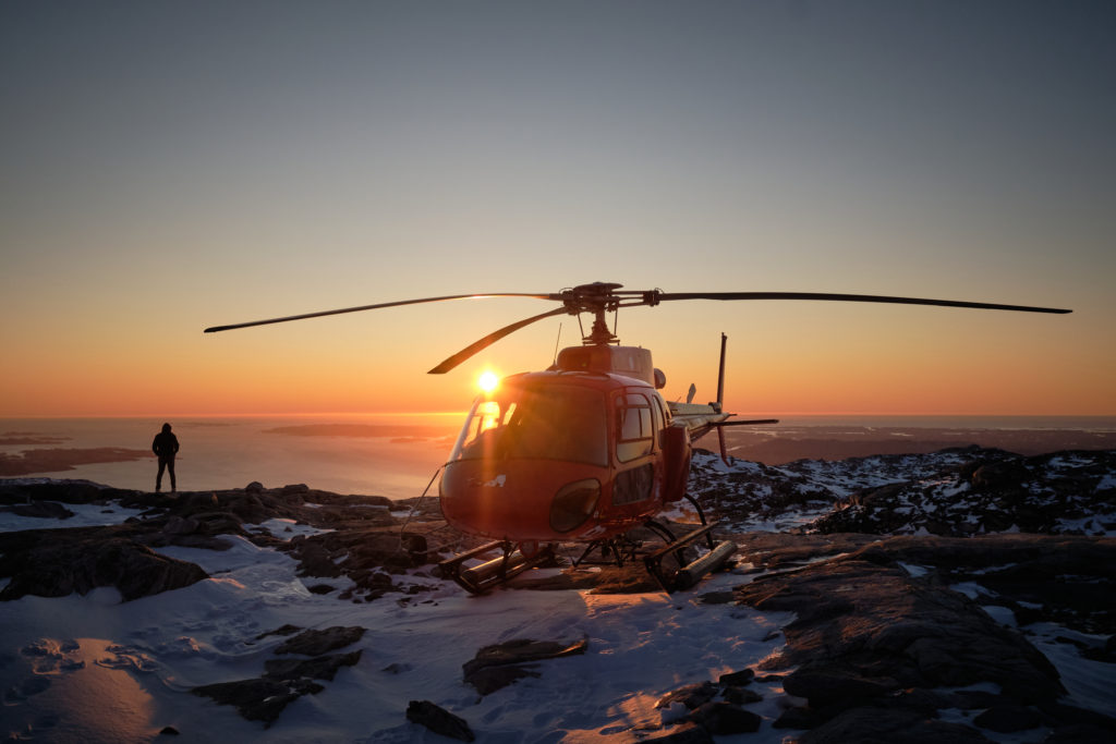 sun setting behind the helicopter on the summit flight - nuuk - West Greenland