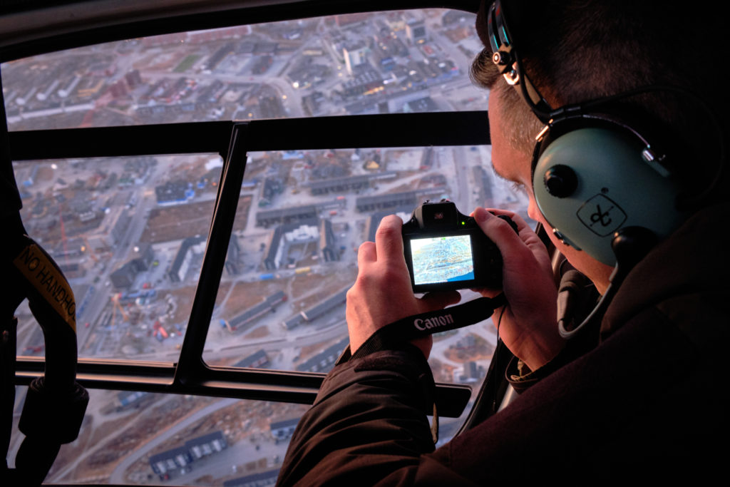 Passenger taking photo as we circle over Nuuk center on helicopter summit flight - West Greenland