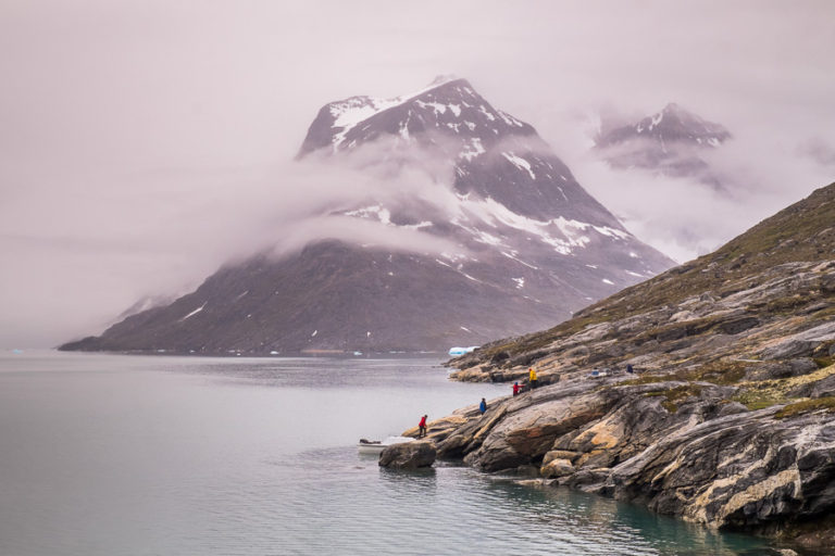 The group helping to re-load the rest of our gear into the speedboats, dramatic mountain in the background