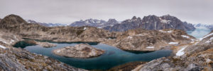 A large tarn in the foreground with the Rasmussen Glacier in the background