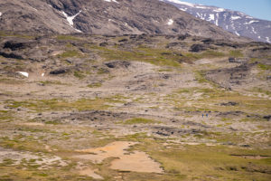 Two of my companions as small dots, hiking through the Moon Landscape on the Lake and Plateau Hike near Igaliku in South Greenland