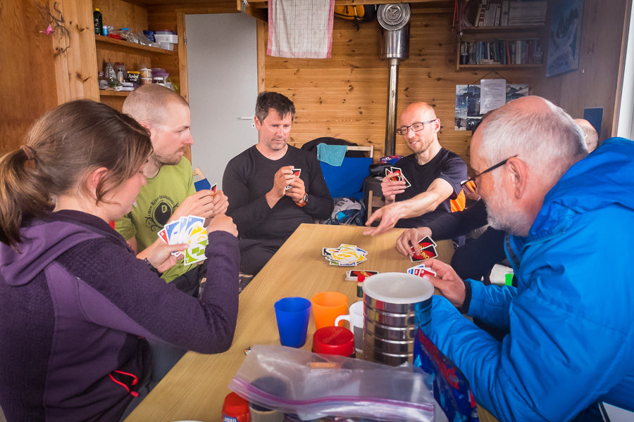 Some of my trekking group around the table in the Tasiilaq Mountain Hut playing UNO - Unplugged Wilderness