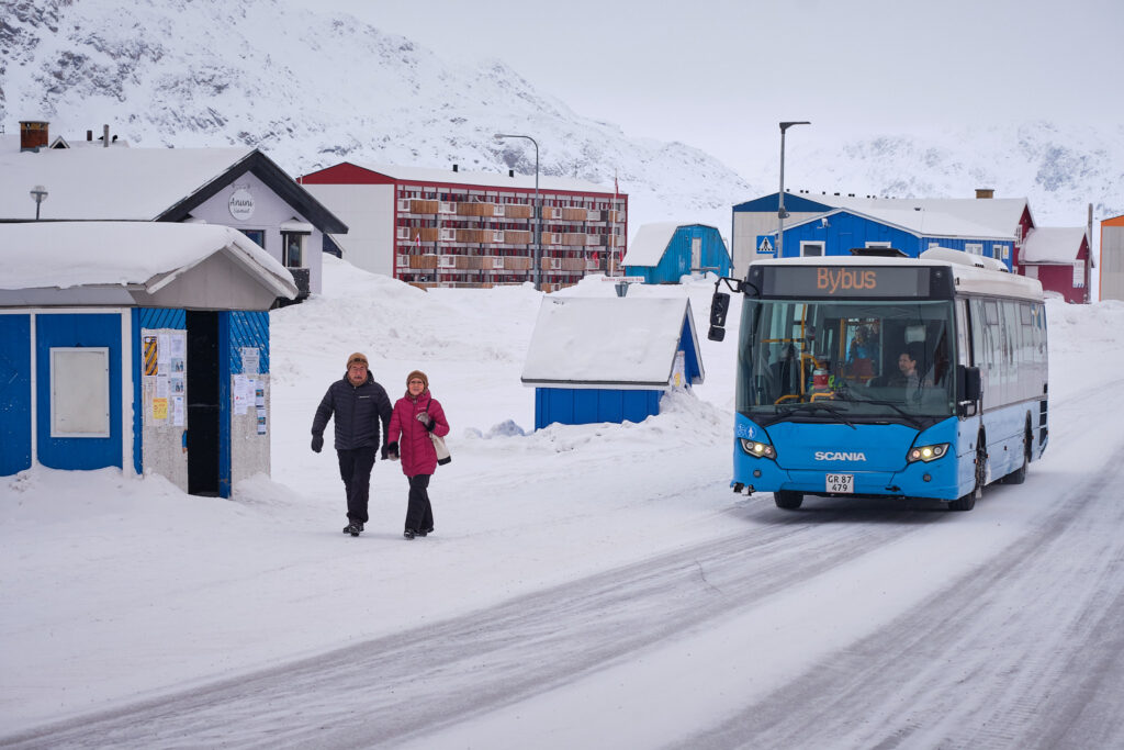 Bus travelling through Sisimiut in winter, illustrating everyday transport and seasonal conditions.