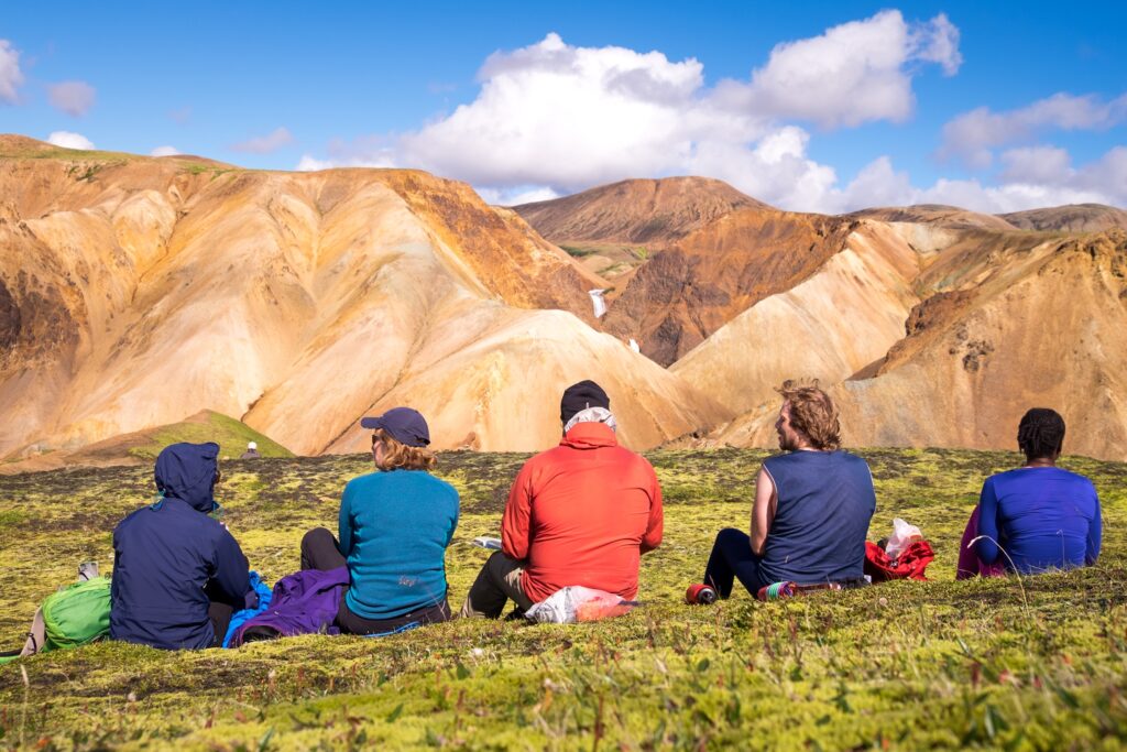 Hikers resting during a multi-day trek in Iceland, showing pace and physical effort.