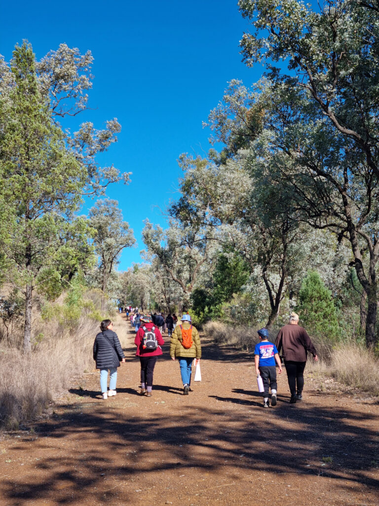 People walking along the gravel path to the Myall Creek Memorial